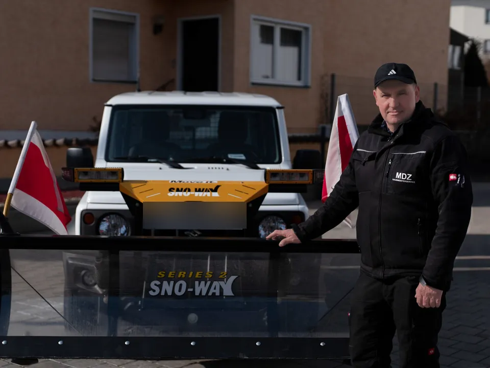 Mirsad Dzafic, Inhaber von MDZ Hausmeisterservice, neben dem Schneeschild seines Winterdienst-Fahrzeugs.